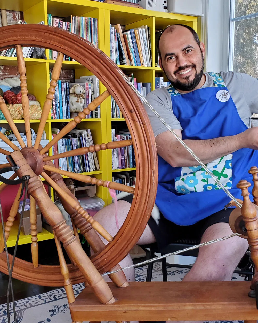 Marcelo file la laine à la main sur un rouet à l'atelier Makeloo
